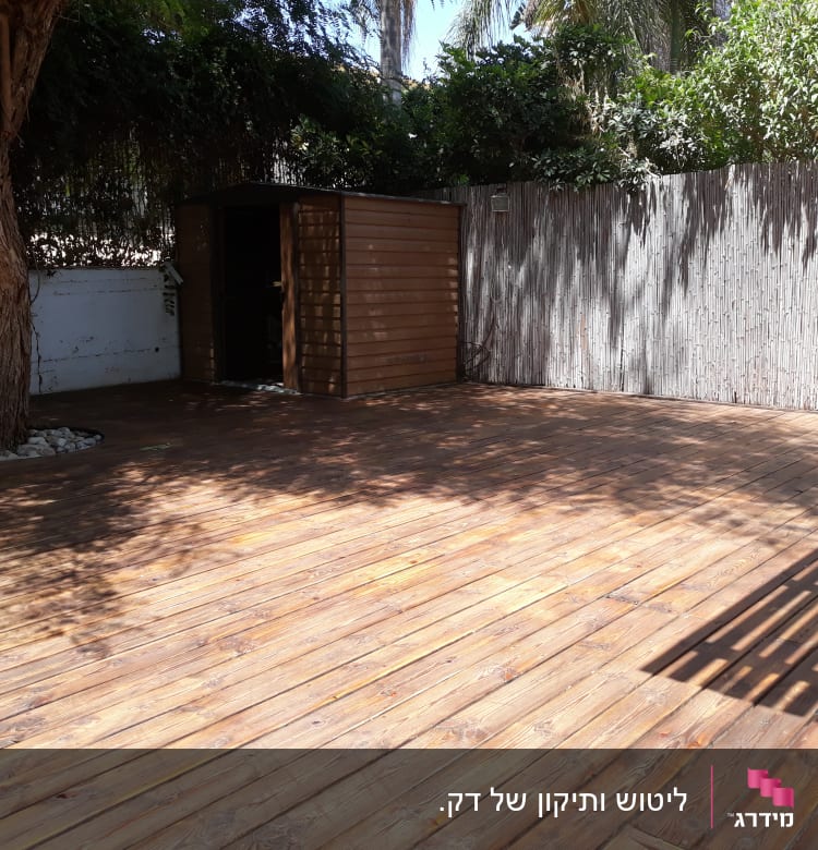 דק עץ עם מחסן וגדר במרפסת גינה